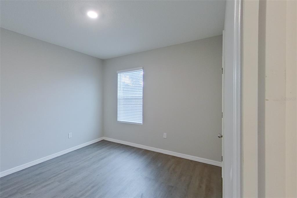 32037 Katelin Circle Leesburg, FL 34748 - Photo 17 of 20 an empty room with wooden floor and windows