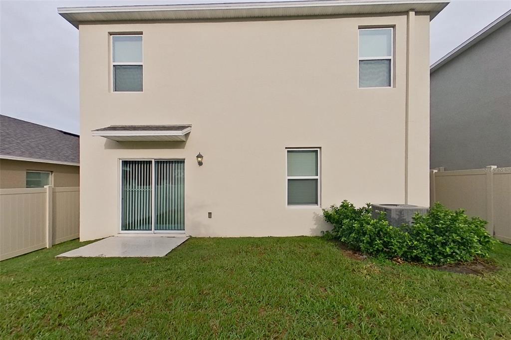 32037 Katelin Circle Leesburg, FL 34748 - Photo 20 of 20 a view of a backyard with potted plants and floor to ceiling window