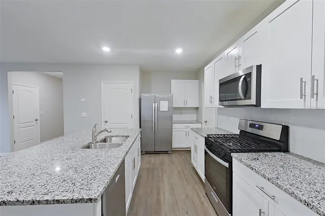 a kitchen with stainless steel appliances granite countertop a sink stove and refrigerator