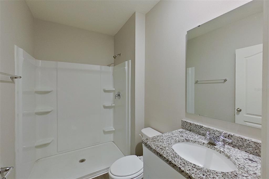 32037 Katelin Circle Leesburg, FL 34748 - Photo 6 of 20 a bathroom with a granite countertop sink toilet and shower