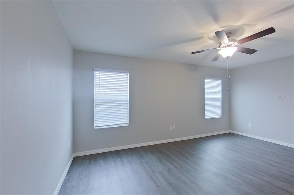 32037 Katelin Circle Leesburg, FL 34748 - Photo 9 of 20 a view of an empty room with wooden floor and a window