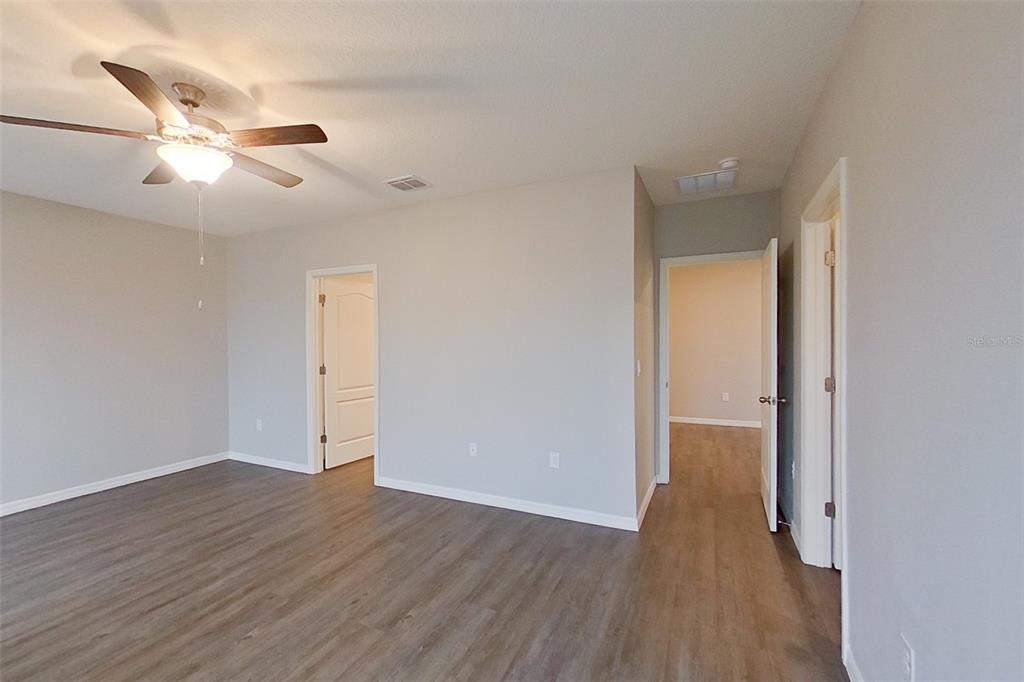 32037 Katelin Circle Leesburg, FL 34748 - Photo 10 of 20 an empty room with wooden floor fan and windows