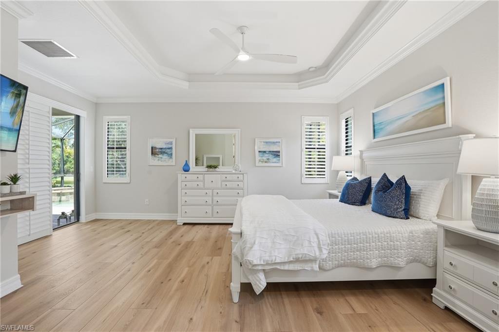 3058 Aviamar Circle Naples, FL 34114 - Photo 11 of 50 Spacious room featuring wood-finish flooring, a tray ceiling with a fan, and crown molding