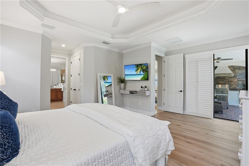 3058 Aviamar Circle Naples, FL 34114 - Photo 12 of 50 Spacious interior featuring wood-finish flooring, a tiered tray ceiling, and crown molding