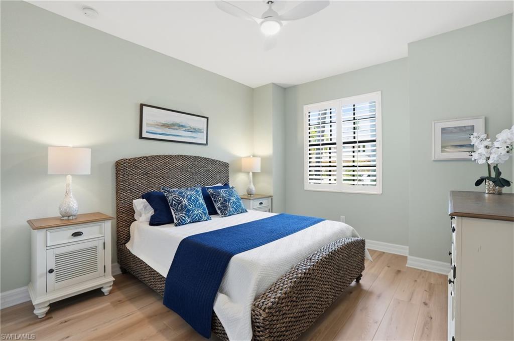 3058 Aviamar Circle Naples, FL 34114 - Photo 17 of 50 Bedroom featuring light wood-finish flooring, a ceiling fan with integrated lighting, and a window with plantation shutters