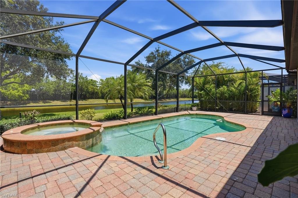 3058 Aviamar Circle Naples, FL 34114 - Photo 23 of 50 Screened lanai featuring a freeform swimming pool and integrated spa with brick-finish surround