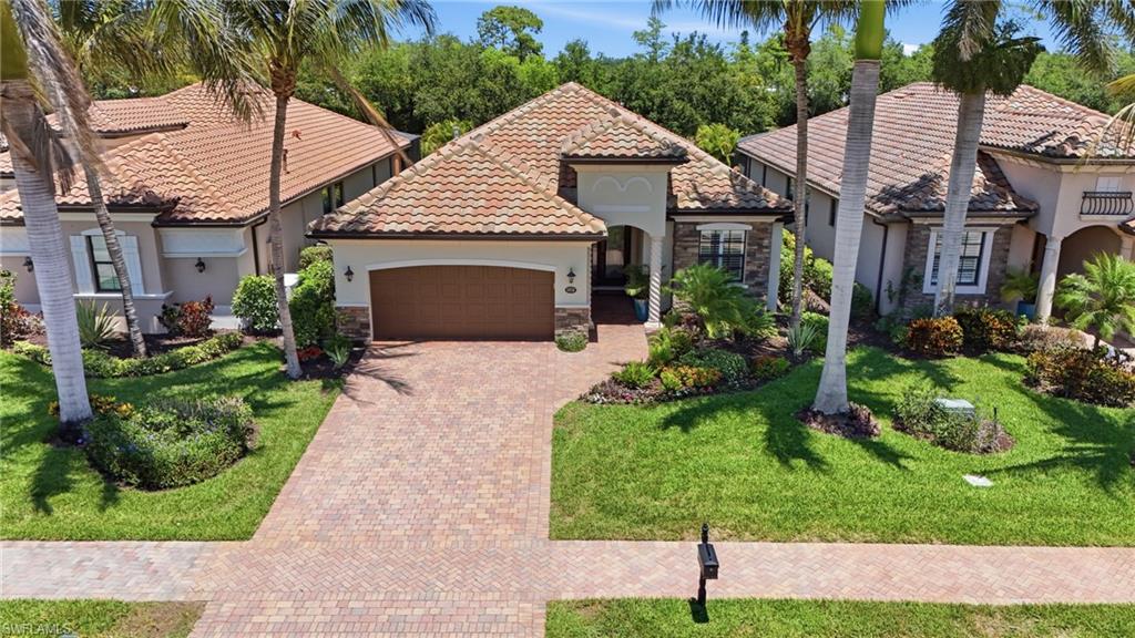 3058 Aviamar Circle Naples, FL 34114 - Photo 26 of 50 Mediterranean-style residence featuring a tile roof, an integrated garage with a wood-finish door, and a paver driveway