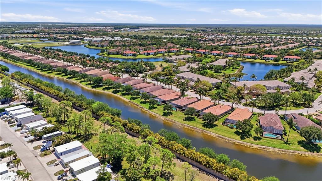 3058 Aviamar Circle Naples, FL 34114 - Photo 34 of 50 Aerial perspective showcasing a residential community with numerous homes featuring terracotta-style roofs, surrounded by lush green landscaping and mature palm trees