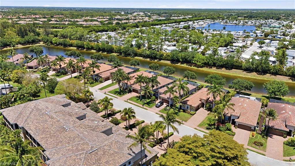 3058 Aviamar Circle Naples, FL 34114 - Photo 39 of 50 Aerial perspective showcasing a residential community with tiled-roof homes, mature landscaping, and an extensive canal system