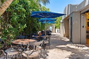 3058 Aviamar Circle Naples, FL 34114 - Photo 49 of 50 Beach Club Paved patio area featuring lush foliage and multiple blue umbrellas