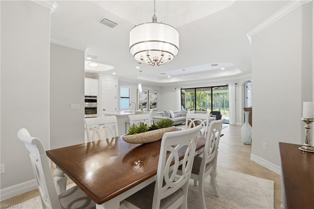 3058 Aviamar Circle Naples, FL 34114 - Photo 7 of 50 Open-concept dining area featuring a tray ceiling, recessed lighting, and a modern drum pendant light fixture
