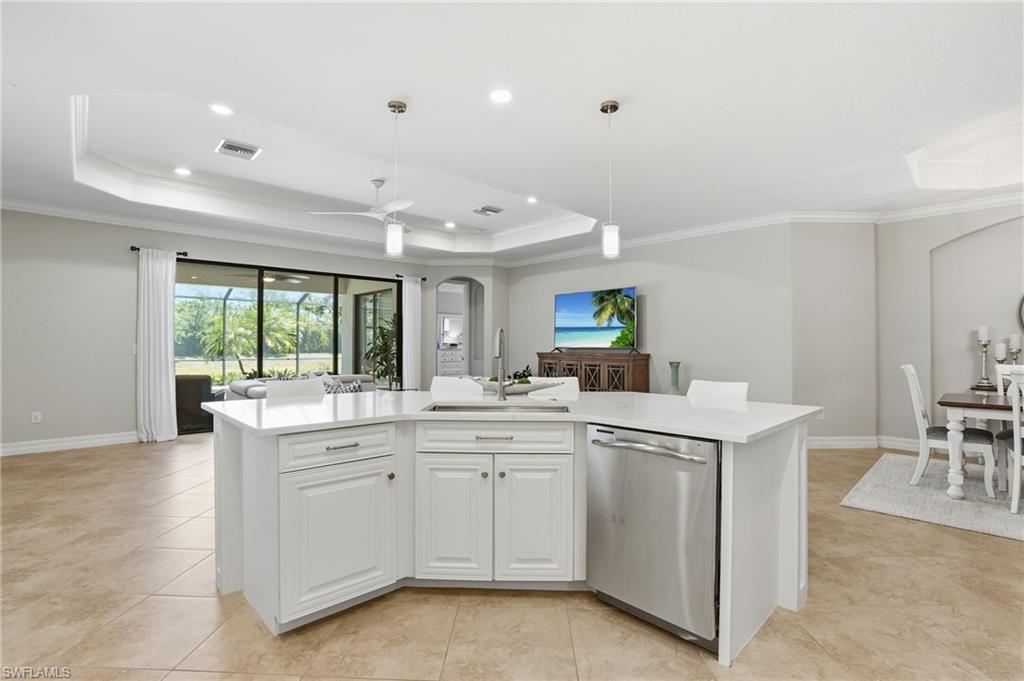 3058 Aviamar Circle Naples, FL 34114 - Photo 8 of 50 Spacious kitchen island with white cabinetry and a light-toned countertop, featuring an undermount sink and stainless steel dishwasher