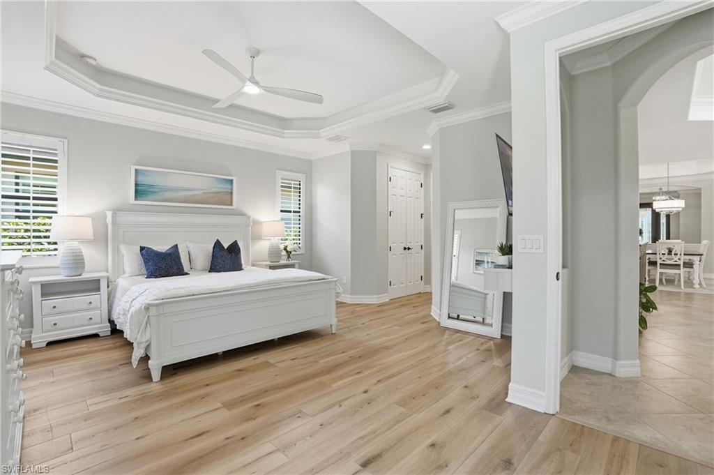 3058 Aviamar Circle Naples, FL 34114 - Photo 10 of 50 Spacious room featuring wood-finish flooring, a tray ceiling with crown molding, and plantation shutters