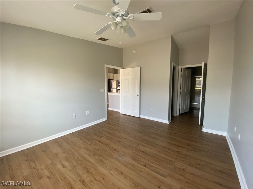 5527 Judith Road Bokeelia, FL 33922 - Photo 4 of 13 an empty room with wooden floor and ceiling fan