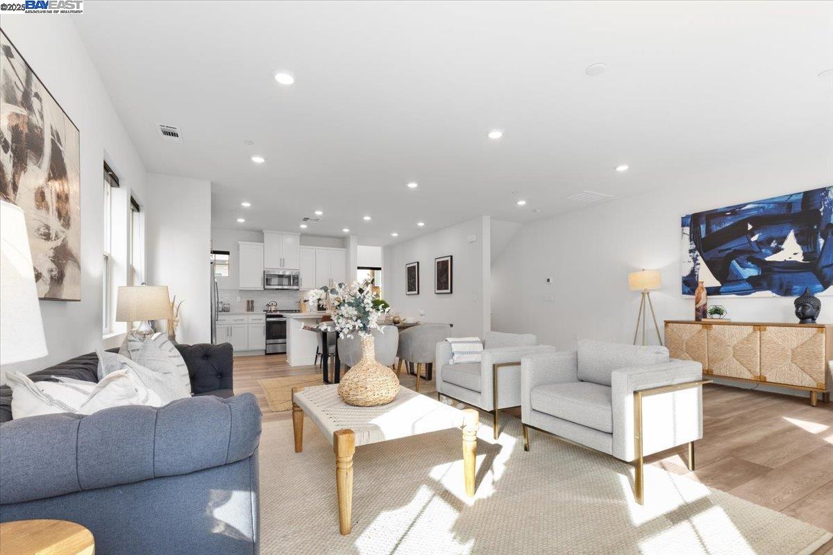 a living room with furniture and a view of kitchen