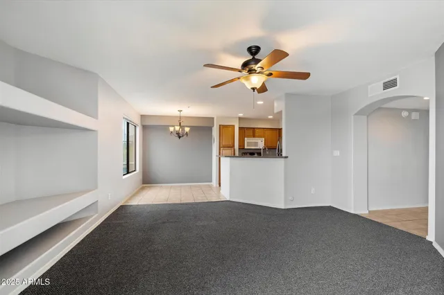 a view of a big room with wooden floor and a ceiling fan