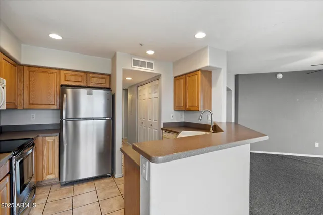 a kitchen with stainless steel appliances granite countertop a refrigerator a sink and a stove