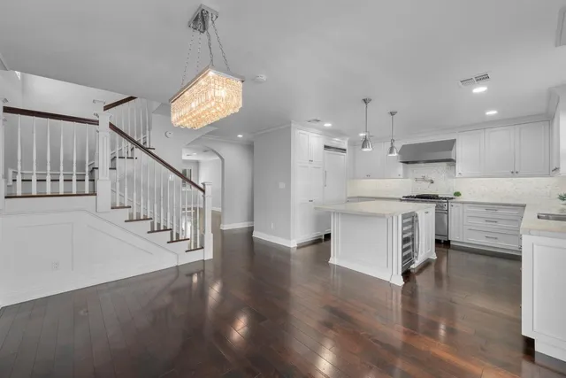 a kitchen with a stove a sink and wooden floor