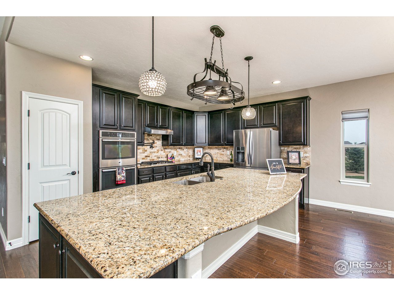 3202 Timeless Circle Berthoud, CO 80513 - Photo 12 of 40 a view of kitchen with cabinets stainless steel appliances and wooden floor