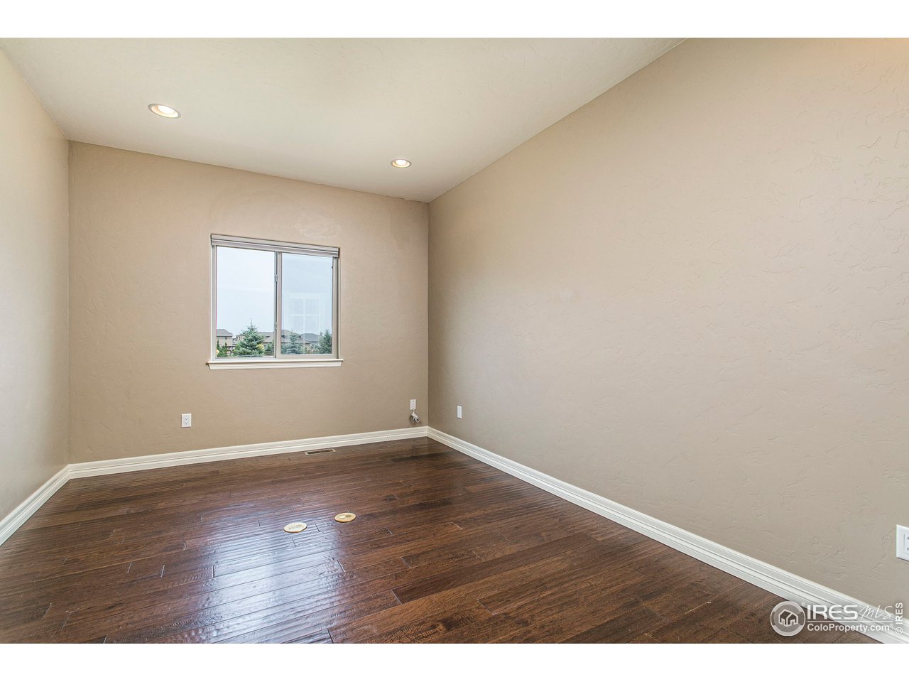 3202 Timeless Circle Berthoud, CO 80513 - Photo 16 of 40 an empty room with wooden floor and windows