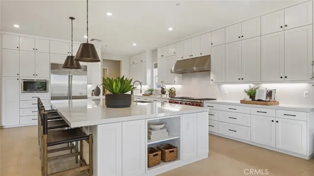 a kitchen with stainless steel appliances kitchen island granite countertop a sink a stove and cabinets