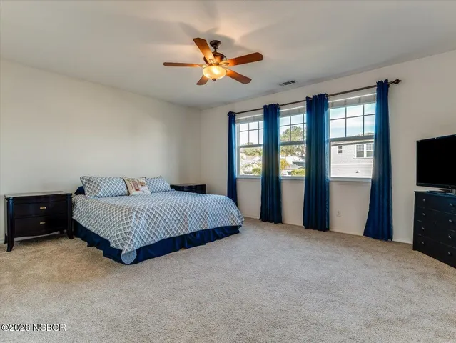 a bedroom with a bed and a chandelier fan