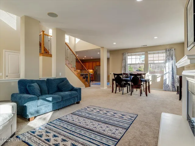 a living room with furniture and a dining table with kitchen view
