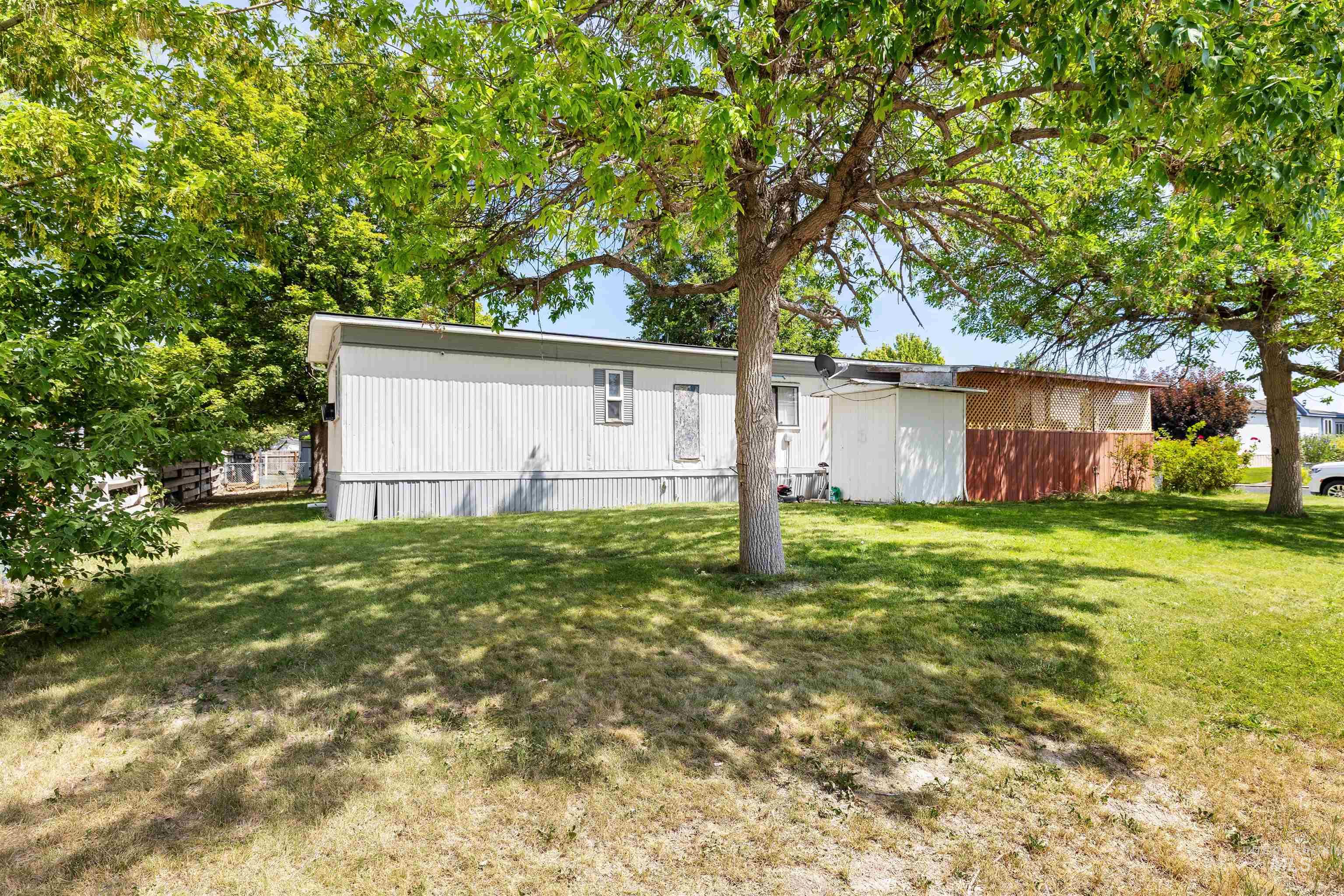 198 South Hills Road, Unit 65 Twin Falls, ID 83301 - Photo 14 of 16 Charming manufactured home situated on a spacious, tree-lined lot featuring mature shade trees and expansive lawn