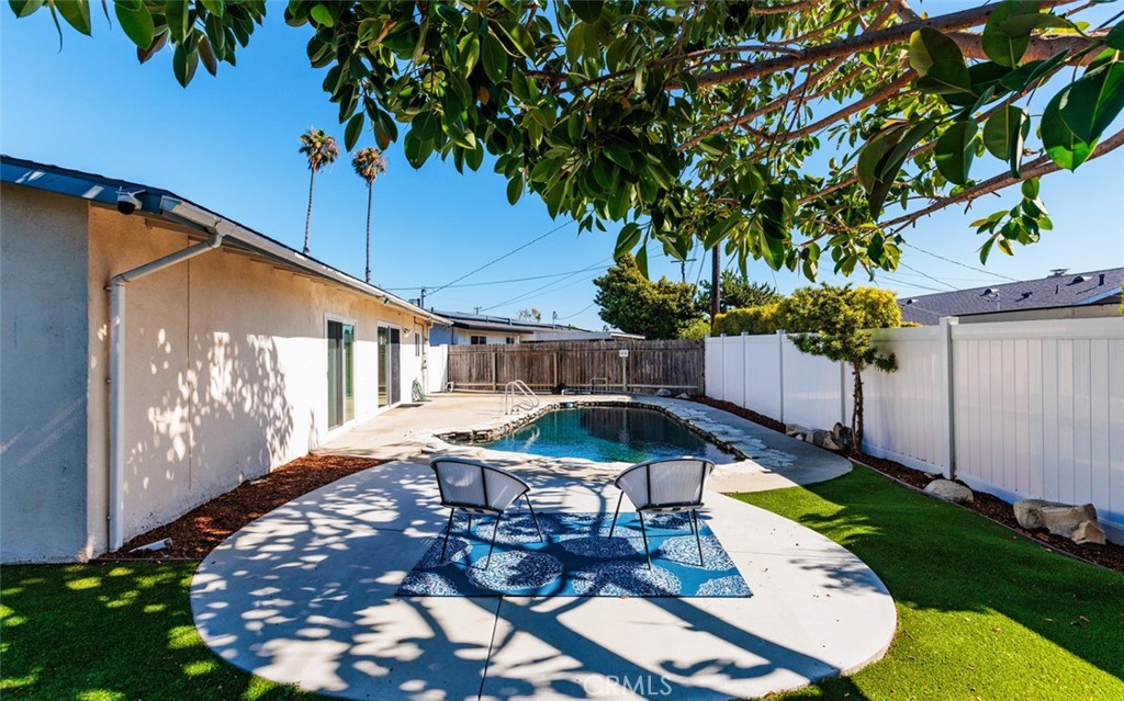 7901 Rhine Drive Huntington Beach, CA 92647 - Photo 15 of 19 a view of a patio with table and chairs potted plants and large tree