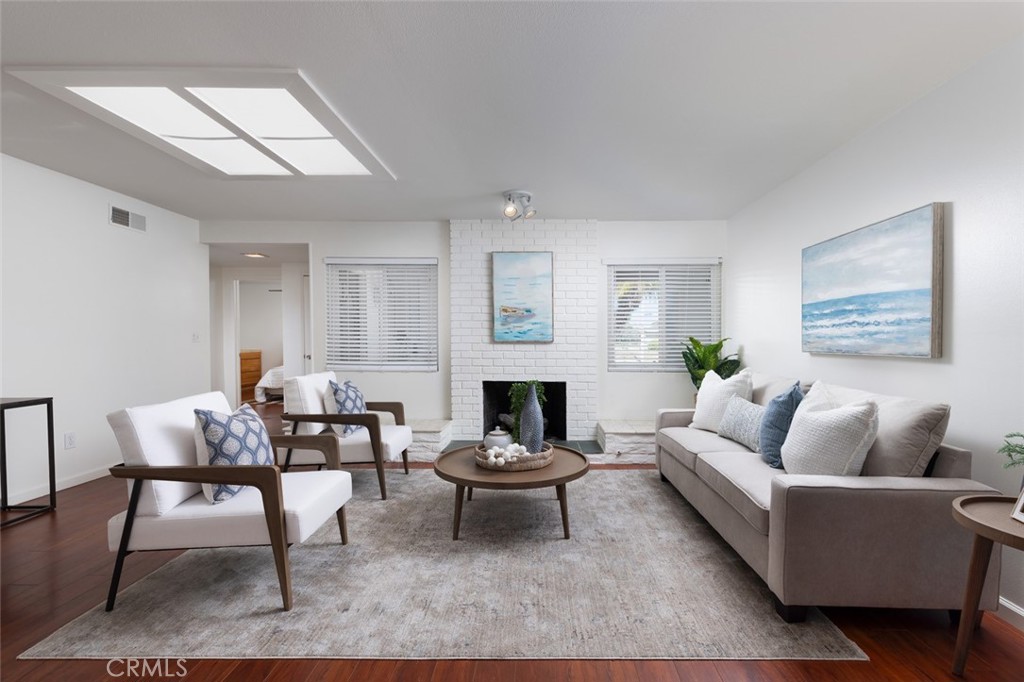 7901 Rhine Drive Huntington Beach, CA 92647 - Photo 4 of 19 a living room with furniture a fireplace and a table