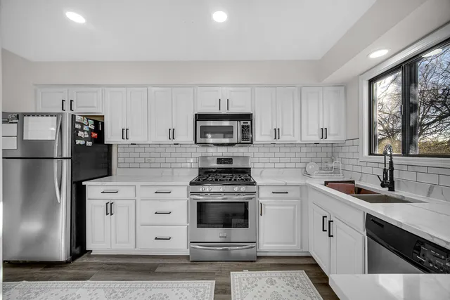 a kitchen with white cabinets and stainless steel appliances
