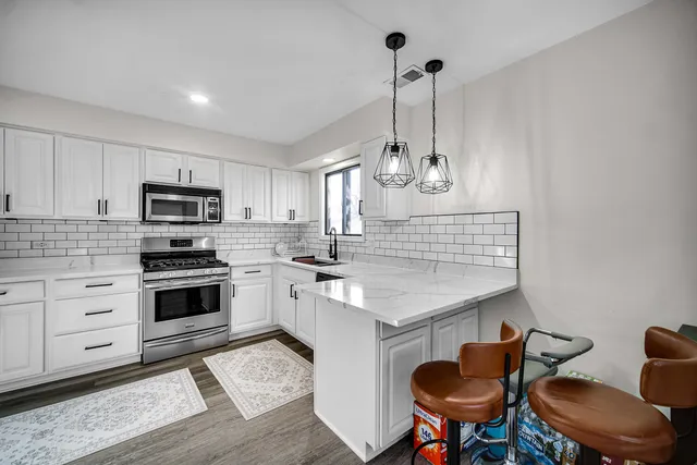 a kitchen with kitchen island granite countertop a sink a center island and cabinets