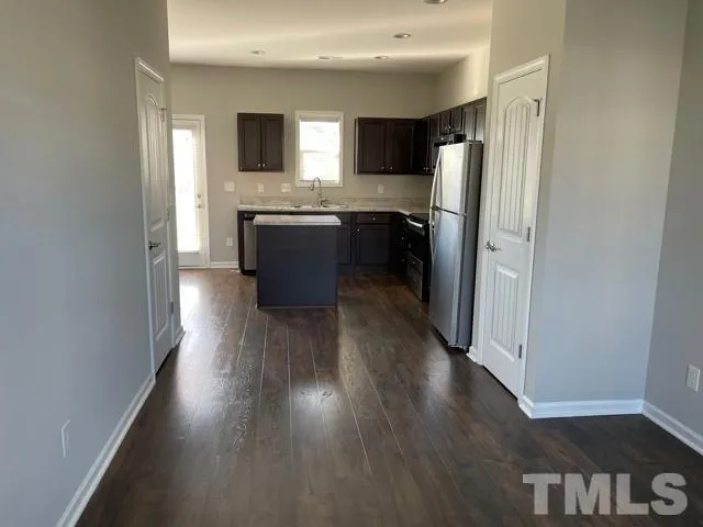 a kitchen with stainless steel appliances a refrigerator and a stove top oven