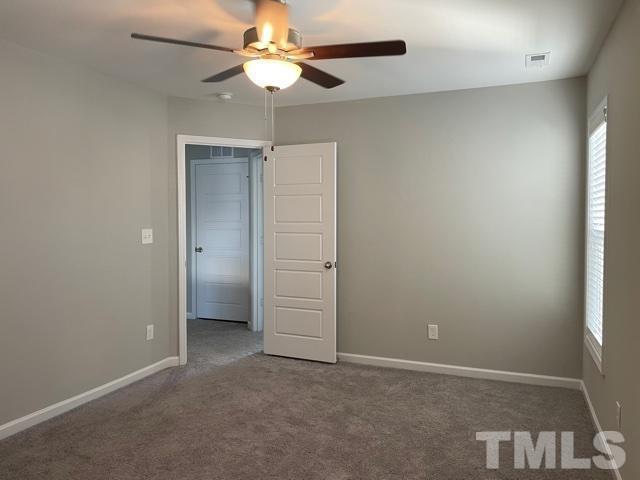 113 Picabo Street Clayton, NC 27527 - Photo 7 of 8 an empty room with closet and a ceiling fan