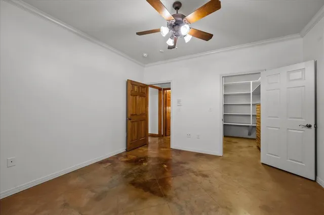an empty room with closet and a ceiling fan