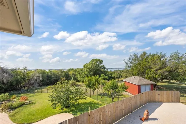 a view of a yard with wooden fence
