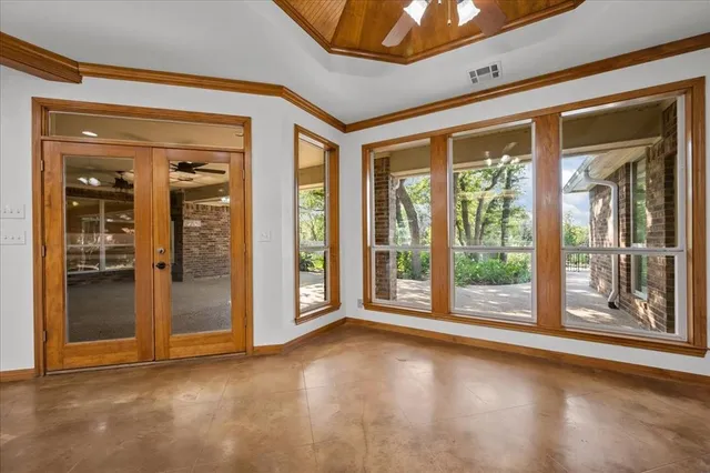a view of a room with large windows and wooden floor
