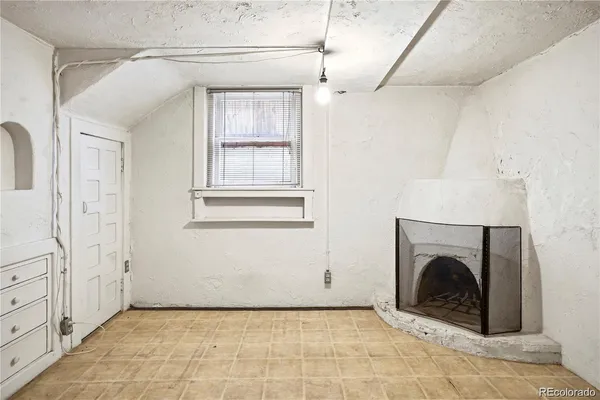 a view of a livingroom with a fireplace and window