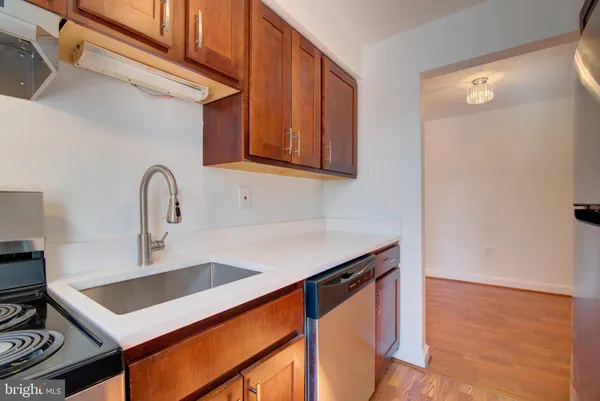 a kitchen with a sink cabinets and wooden floor