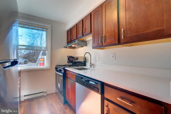 a kitchen with stainless steel appliances granite countertop a sink a stove cabinets and wooden floor