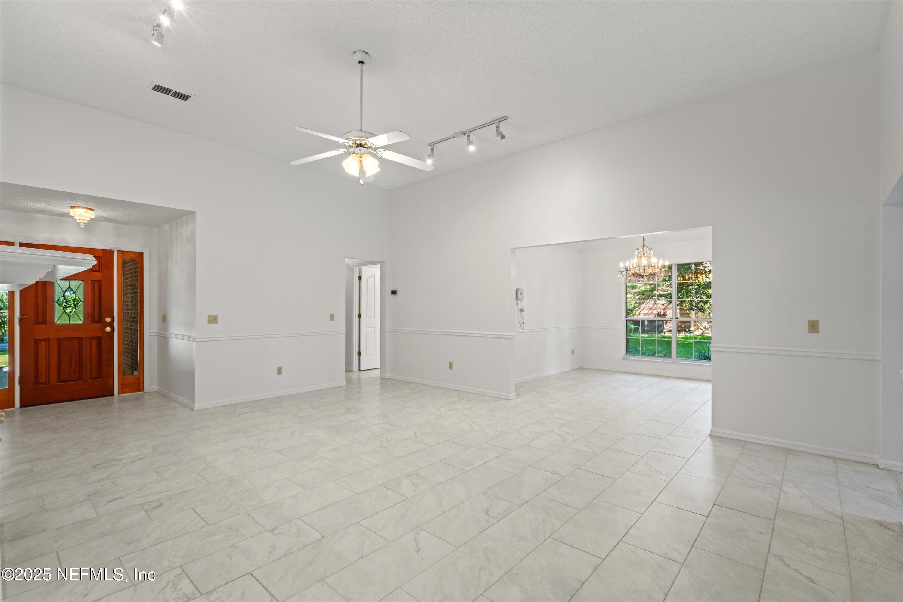 3297 Turtle Creek Road St. Augustine, FL 32086 - Photo 13 of 35 an empty room with chandelier fan and windows