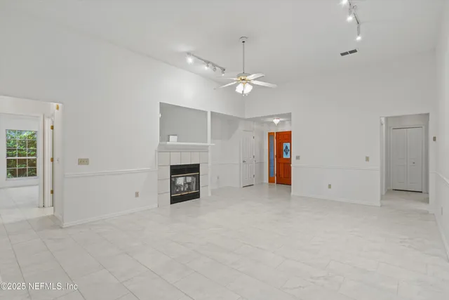a kitchen with white cabinets appliances a sink and a window