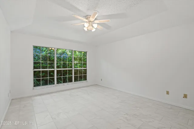 an empty room with windows and fireplace