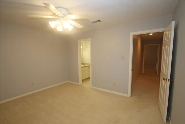 an empty room with closet and a chandelier fan