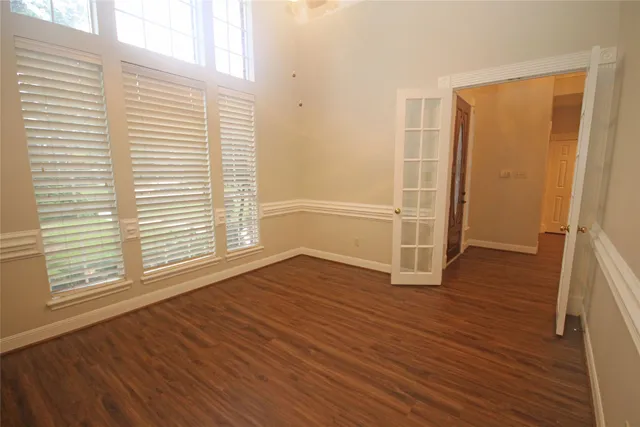 an empty room with wooden floor and a window