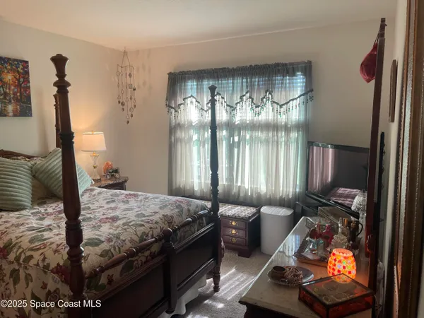 a bedroom with a bed and large windows