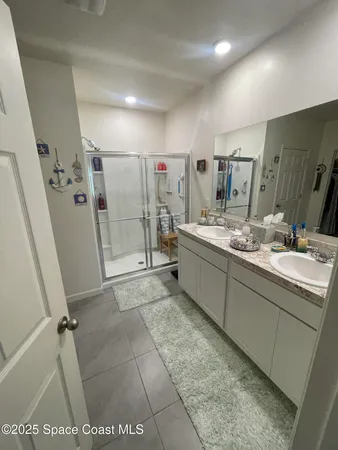 a bathroom with a sink mirror and a shower