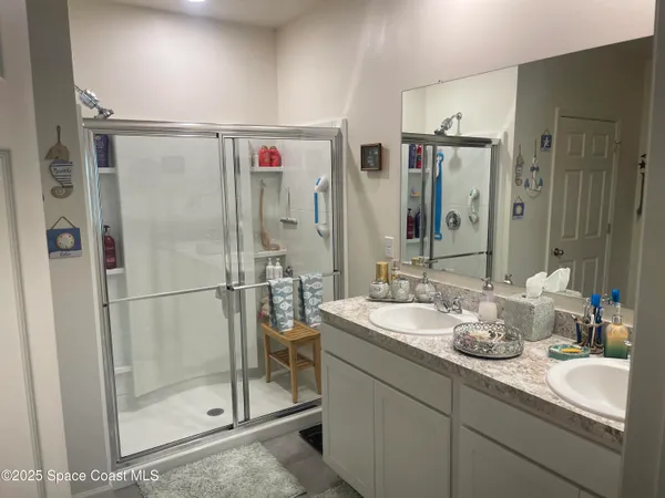 a bathroom with a shower sink and mirror