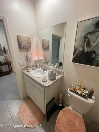 a bathroom with a granite countertop toilet sink and mirror