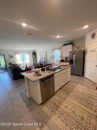 a kitchen with stainless steel appliances granite countertop a stove top oven a sink dishwasher and white cabinets